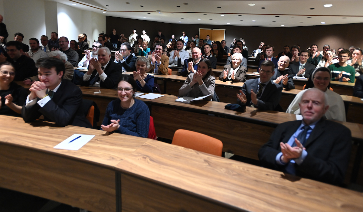 the audience in a full Aquinas Lecture Hall applauds Dr. Gorman